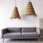 Duo of large straw pendant lamps complementing contemporary gray sofa seating area