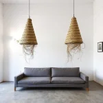 Three handwoven straw pendant lights with artisanal chevron pattern suspended over dining table