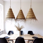 Three conical straw pendant lamps creating ambiance over rectangular dining table