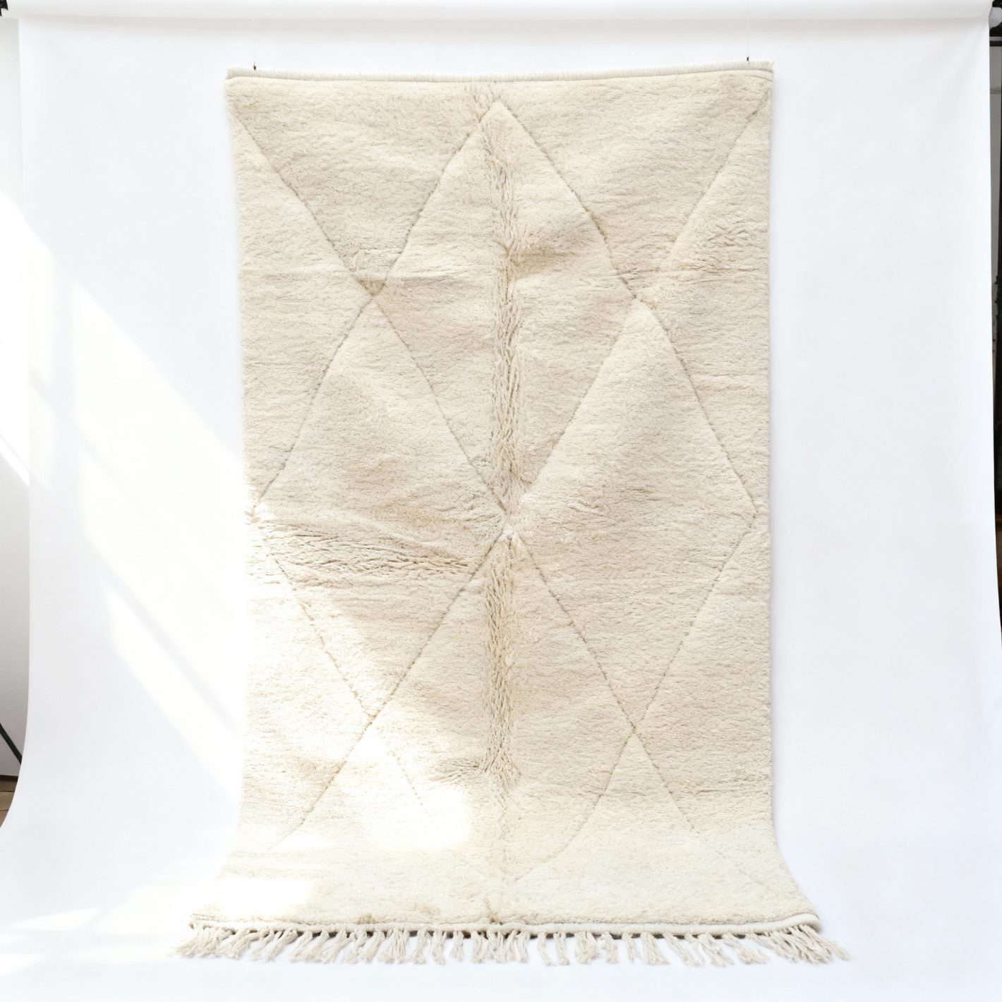 White Moroccan Rug (6.5×10 FT) (2) White Moroccan rug with diamond geometric pattern and fringe, handmade wool texture close-up view