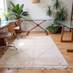 White Moroccan rug geometric pattern in bright home office with plants and natural wood desk