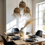 Three handwoven straw pendant lights above dining table with black place settings