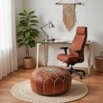 Round tan leather floor ottoman with star embroidery on a natural jute rug in a bright home office
