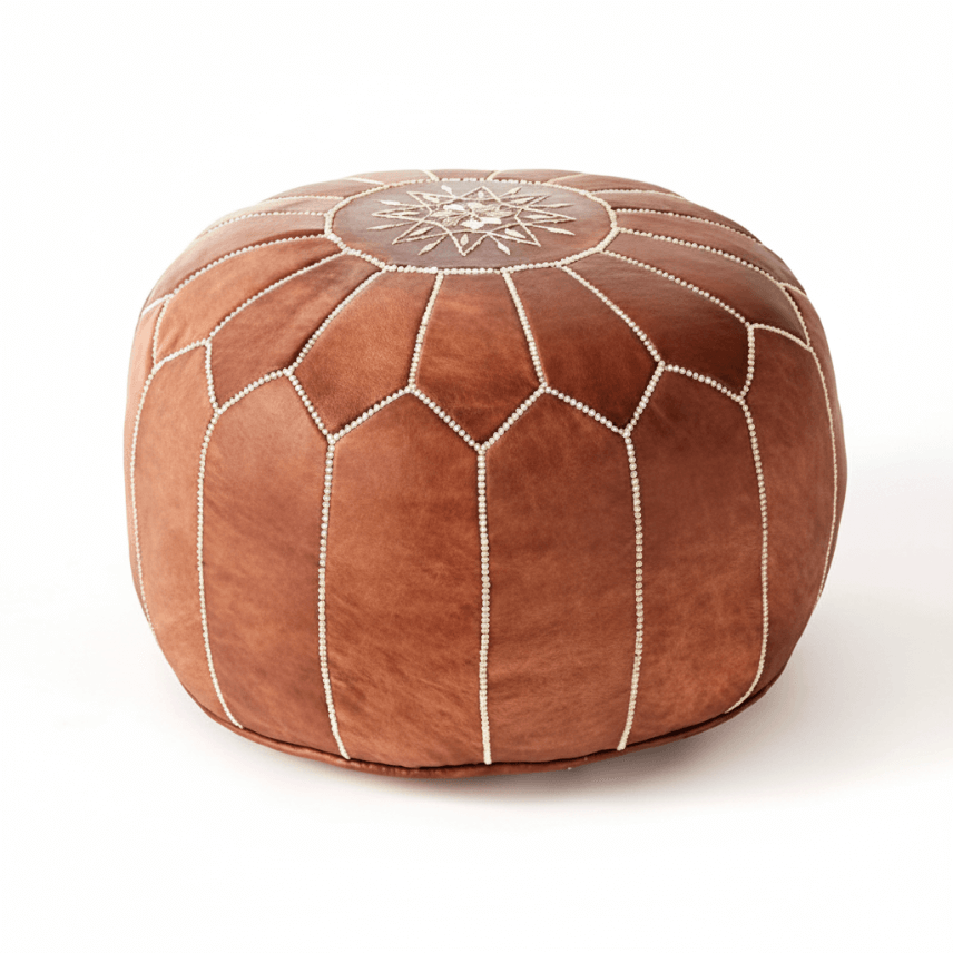 Handcrafted tan leather pouf with white embroidered snowflake pattern, top view Tan leather floor ottoman with white star embroidery and geometric stitching, handcrafted Moroccan pouf design