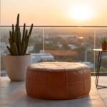Large leather floor ottoman on geometric rug in modern loft with exposed concrete and steel beams