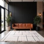 White Moroccan geometric rug in modern lobby with tan leather sofa and plants, 6.5x10 feet