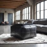 Black leather square pouf as coffee table ottoman in industrial loft with modern gray sofa