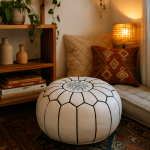 White leather floor ottoman pouf with star embroidery in cozy living room next to ethnic patterned pillows