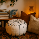 White leather floor ottoman 21 inch with geometric black stitching near bookshelf and woven lamp in warm room