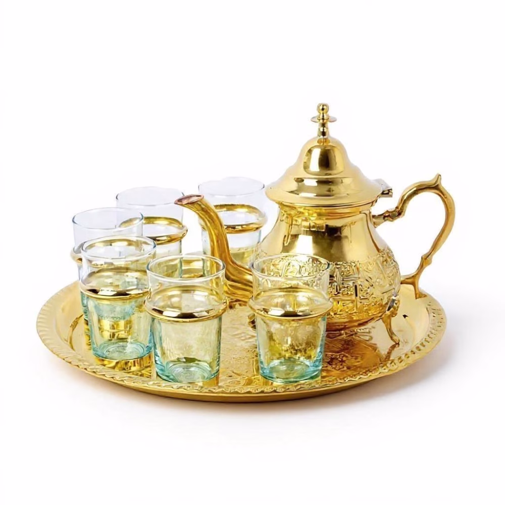 Luxurious traditional moroccan tea set gold featuring hand-engraved brass teapot, matching tray, and 6 traditional tea glasses arranged elegantly