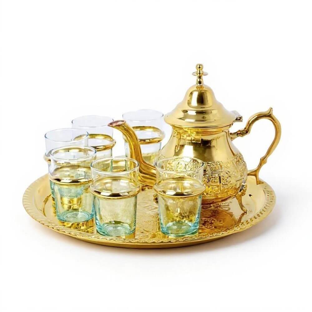 Luxurious traditional moroccan tea set gold featuring hand-engraved brass teapot, matching tray, and 6 traditional tea glasses arranged elegantly