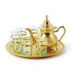 Luxurious traditional moroccan tea set gold featuring hand-engraved brass teapot, matching tray, and 6 traditional tea glasses arranged elegantly