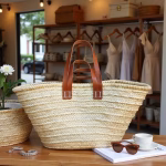 Straw tote bag with leather handles displayed with resort accessories