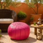 Pink leather round ottoman on outdoor patio with Moroccan tea set - handcrafted floor pouf with embroidery