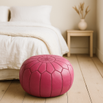 Pink leather round ottoman on bedroom floor near bed - 21 inch handcrafted pouf with decorative stitching