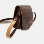 Brown leather shoulder bag styled with vintage travel accessories