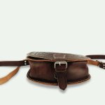 Brown leather shoulder bag flat lay showing bottom construction and adjustable strap detail