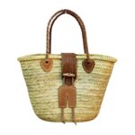 "Crafted from handwoven palm leaf with braided leather handles and a wooden toggle closure — this Moroccan market basket goes from souk to shore." - 128 chars ✓