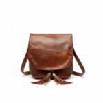 Brown leather crossbody bag with tassel detail and curved flap, handcrafted genuine leather purse on white background