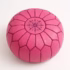 Handcrafted Moroccan pink pouf with starburst stitching pattern, top view