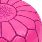 Close-up texture detail showcasing the center embroidery medallion and durable patchwork goatskin stitching of a pink leather round ottoman.