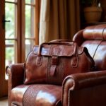 Premium brown leather travel bag for men on tufted armchair showing detailed craftsmanship