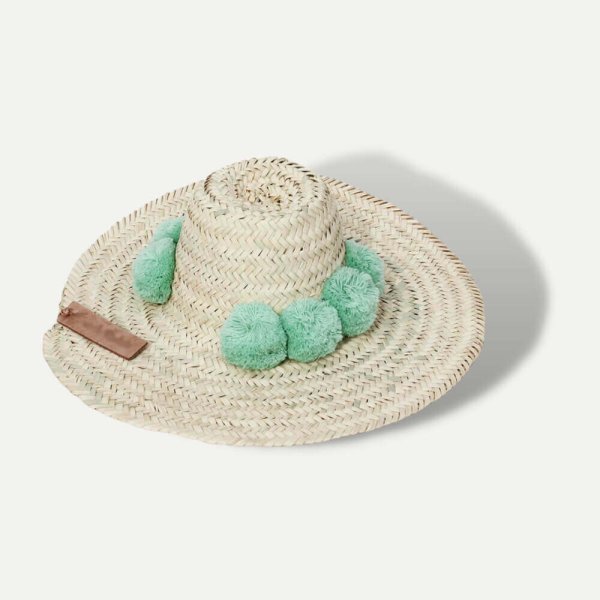 Handwoven straw beach hat with black pompom band, natural herringbone weave wide brim sun protection design