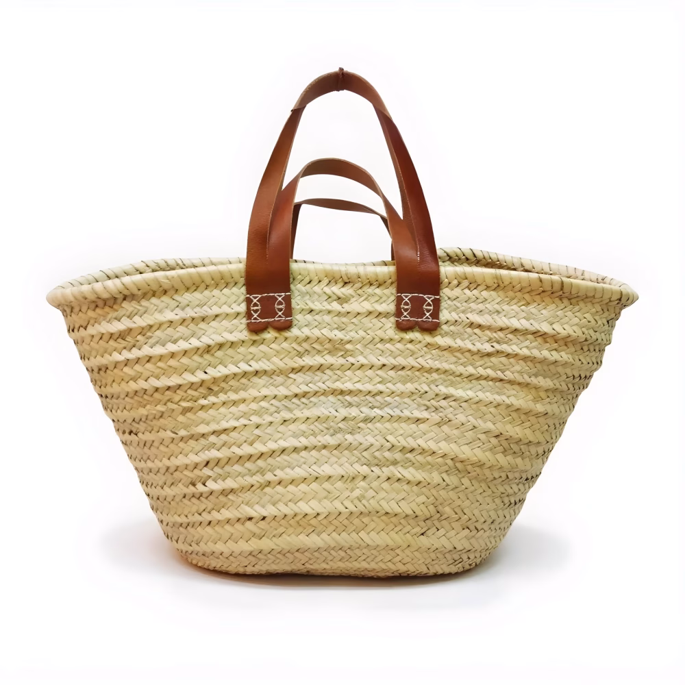 Natural straw tote bag with dual leather handles on white background