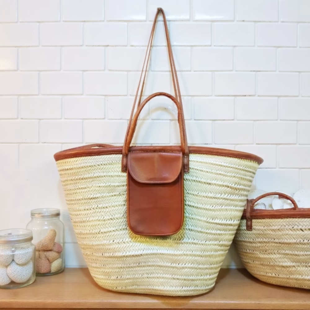 Straw beach bag with leather pocket styled in modern kitchen setting
