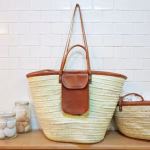 Straw beach bag with leather pocket styled in modern kitchen setting