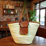Natural straw beach bag with leather pocket in rustic interior setting