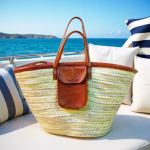 Handwoven straw beach bag with leather details on yacht deck