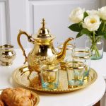 Side view of gold tea set highlighting ornate handle and spout details