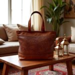 Handwoven leather tote bag with basketweave center panel on wooden coffee table
