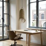 Handwoven straw lighting pendant beside white floating shelves creating organic textural accent in room