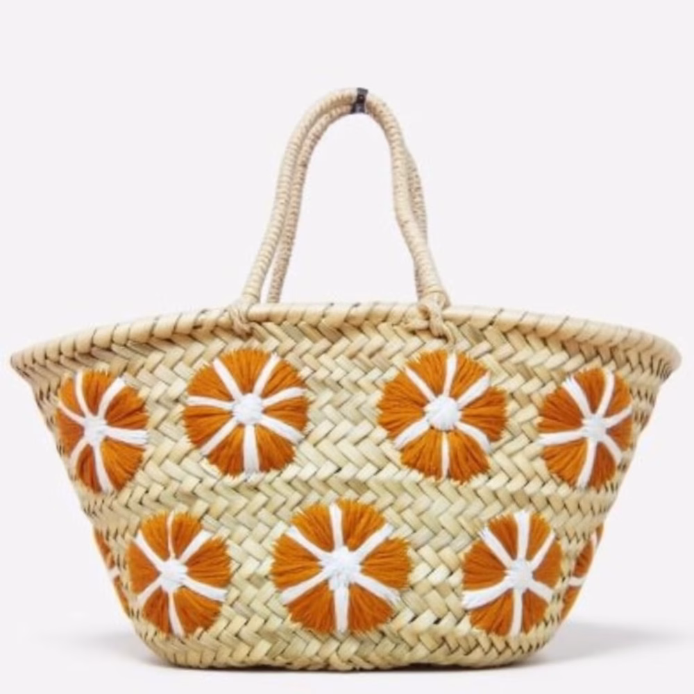 Small straw bag with orange floral embroidery on white background