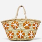 Small straw bag with orange floral embroidery on handwoven palm leaf basket tote