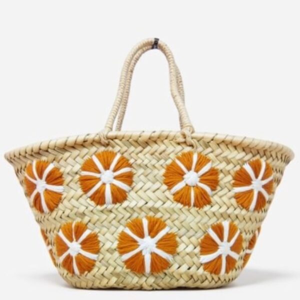 Small straw bag with orange floral embroidery on handwoven palm leaf basket tote