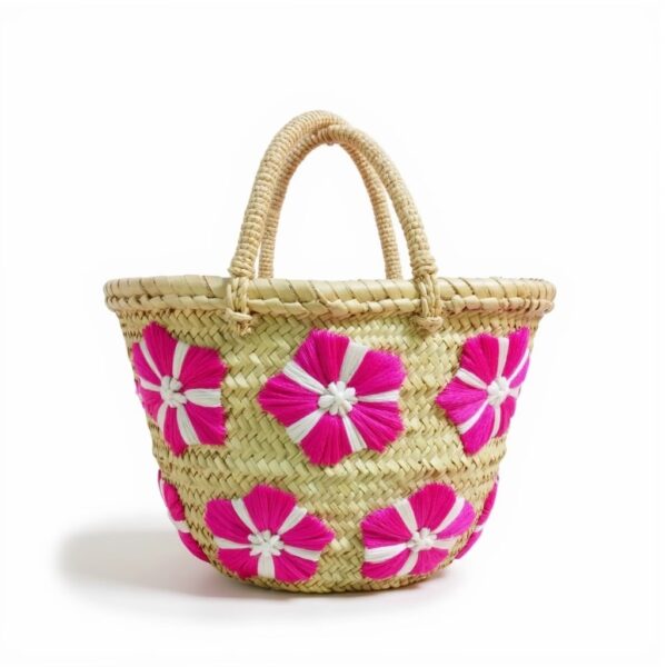 Small straw bag with fuchsia floral embroidery on handwoven palm leaf basket with braided handles