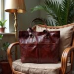 Burgundy brown leather tote bag on rattan chair with brass buckles and contrast stitch detail