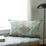 Handwoven cactus silk pillow 36 inch with terracotta diamond embroidery on cushioned seat by window