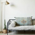 Handwoven cactus silk pillow 36 inch lumbar cover with tassels on daybed with gold floor lamp and cactus