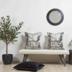 Gray floral pillow covers displayed on modern white bench with minimalist decor