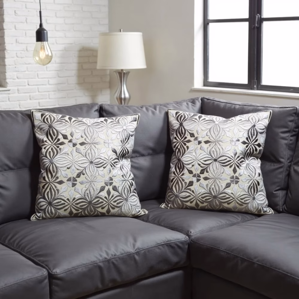 Set of embroidered gray Moroccan pillow covers on dark sofa