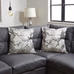 Set of embroidered gray Moroccan pillow covers on dark sofa
