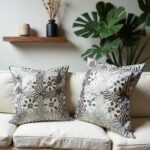 Gray floral pillow covers close-up on velvet burgundy chair showing embroidery texture
