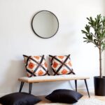 Berber diamond pillow covers styled on wooden bench with round mirror in minimalist Scandinavian interior