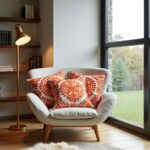 Orange medallion embroidered cotton cushion set on white sofa with monstera plant and floating shelves