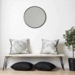 Decorative embroidered cotton pillow covers with medallion pattern displayed on bench under round mirror