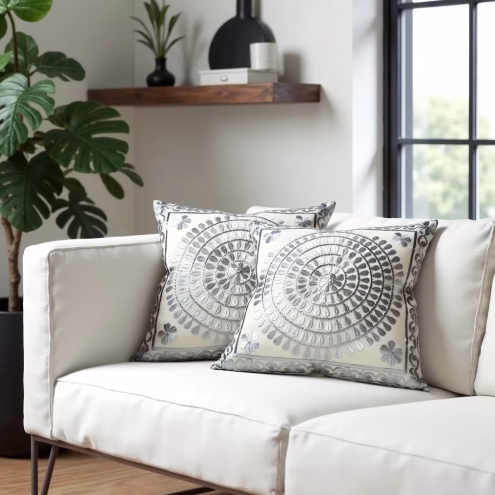 Gray embroidered pillow covers with circular pattern on white sofa
